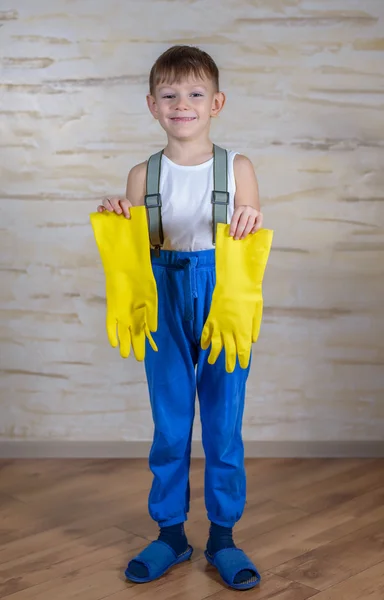 Ernster Junge in Hausschuhen zieht Handschuhe an — Stockfoto