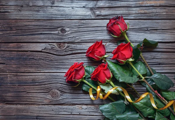 Romantik bir ahşap yüzey üzerinde kırmızı gül buketi — Stok fotoğraf