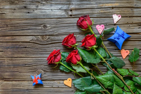 Worn out wooden background with stemmed roses — Stock Photo, Image