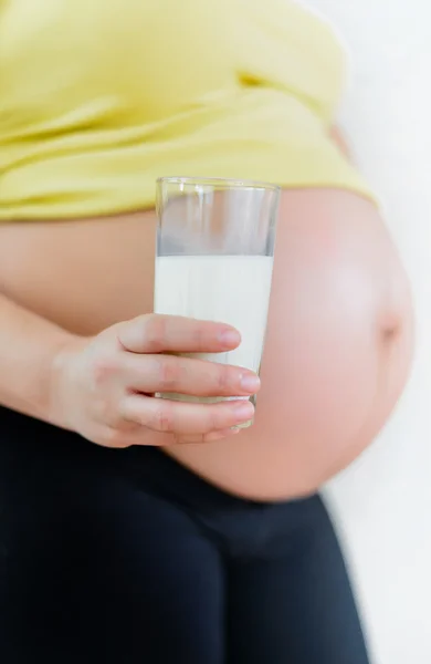Těhotná žena drží sklenici čerstvého mléka — Stock fotografie
