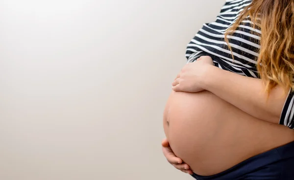 Close up of the bare belly of a pregnant woman — Stock Photo, Image