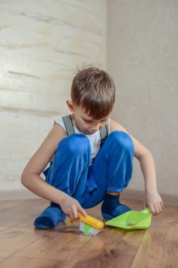 Child using toy broom and dustpan