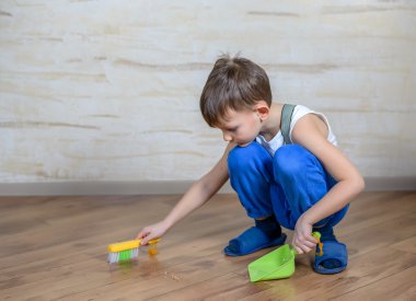 Child using toy broom and dustpan
