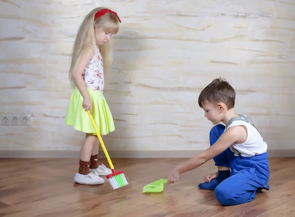 Cute children using toy broom and dustpan — Stock fotografie