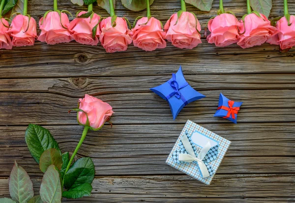 Trois coffrets cadeaux sur fond en bois avec des roses — Photo