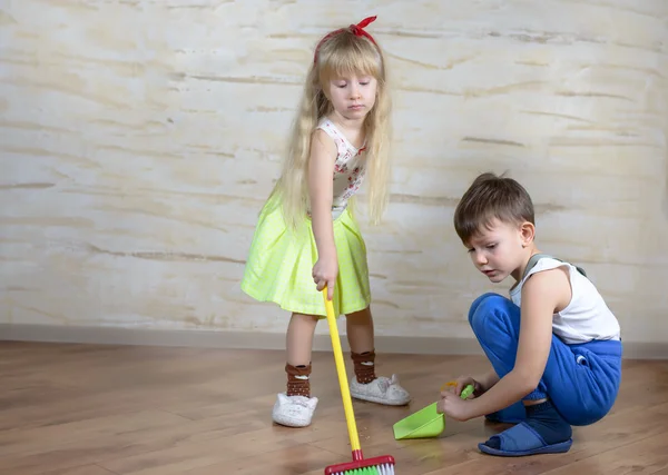 Cute children using toy broom and dustpan — Stock Photo, Image