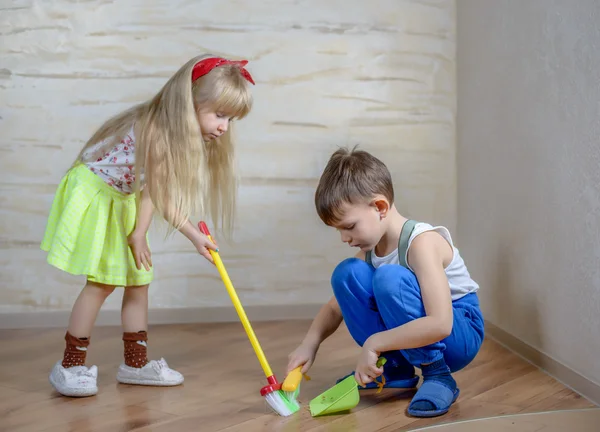 Crianças bonitos usando vassoura de brinquedo e espanador — Fotografia de Stock