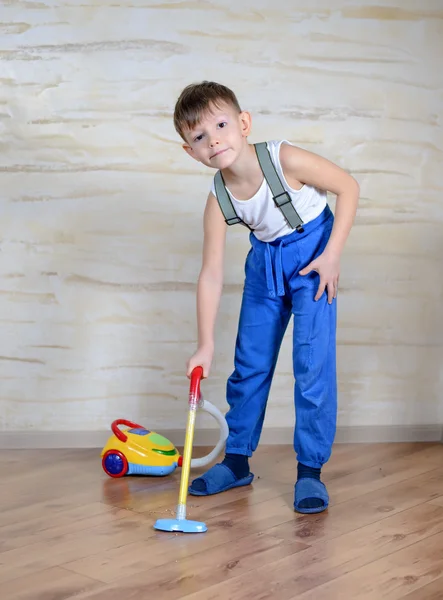 Cute boy using toy vaccuum