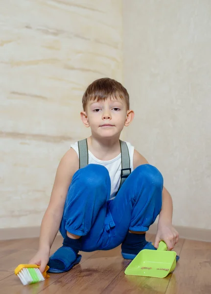 Child using toy broom and dustpan — Stok fotoğraf