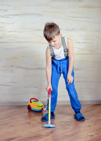 Cute boy using toy vaccuum