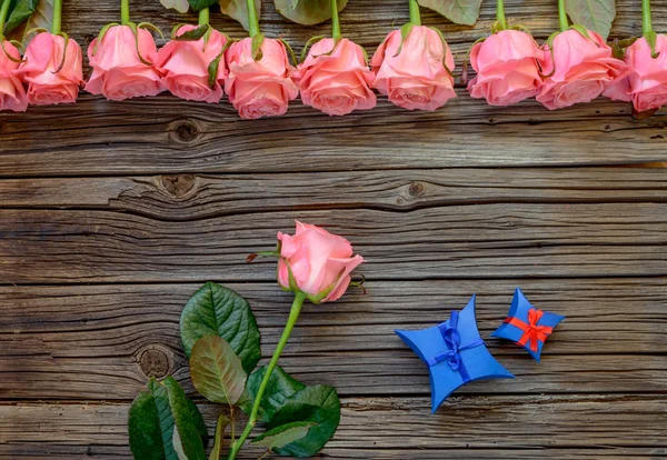 Güller ile ahşap arka plan üzerinde Hediye kutuları