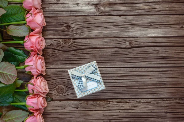 Row of roses with gift box and copy space — Stock Photo, Image