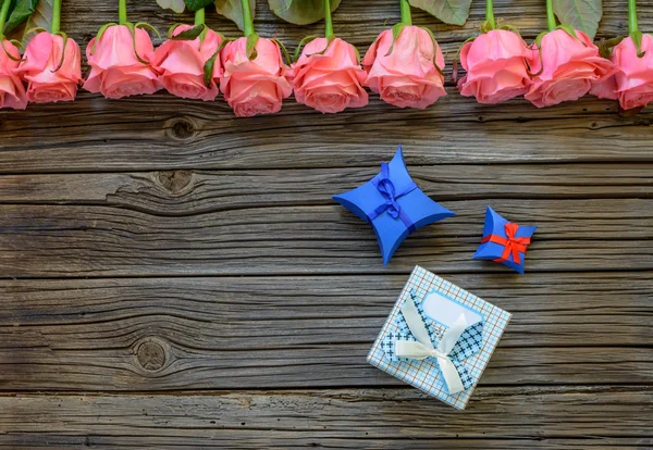 Tres cajas de regalo sobre fondo de madera con rosas — Foto de Stock