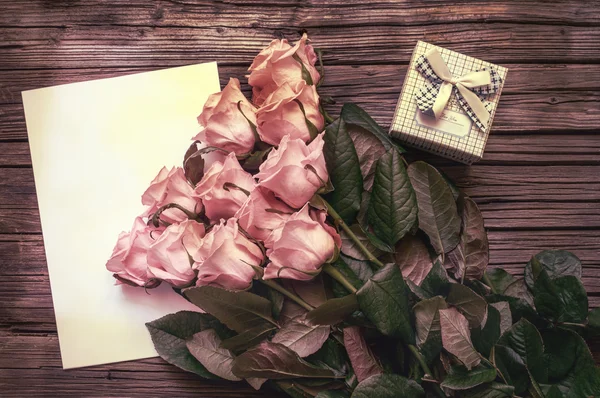 Rosas cor-de-rosa sobre papel em branco com caixa de presente — Fotografia de Stock