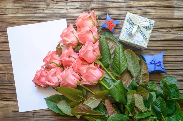 Ροζ τριαντάφυλλα πάνω από κενό χαρτί με κουτί δώρου — Φωτογραφία Αρχείου