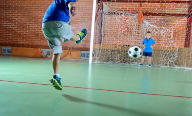 Genç çocuk hedef için bir futbol topu tekmeleme