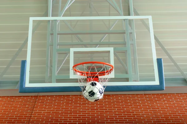 Balón de fútbol pasando por un aro de baloncesto — Foto de Stock