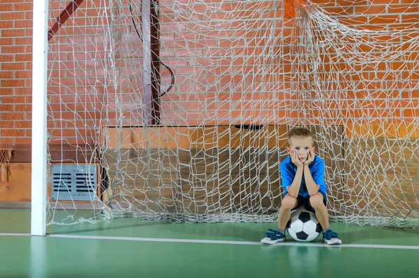 Jongen speelt keeper houdt een voetbal — Stockfoto