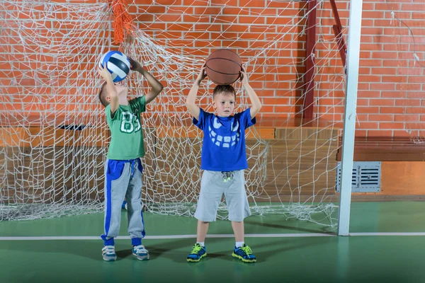 Two young boys playing on an indoor court — Stock Photo, Image