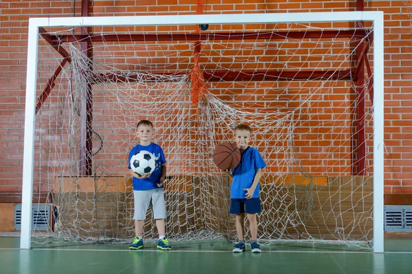 Deux jeunes écoliers jouant au ballon ensemble — Photo