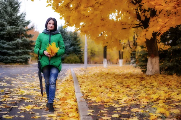 Mujer soltera caminando en la acera con hojas —  Fotos de Stock