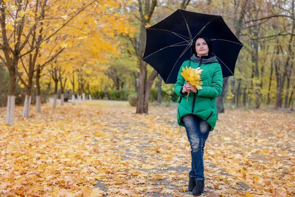 Mujer soltera caminando entre hojas caídas — Foto de Stock