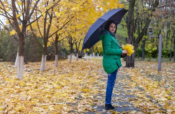 Samotna kobieta chodząca wśród upadłych liści — Zdjęcie stockowe