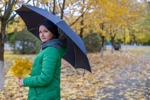 Jediná žena stojící na chodníku s listy — Stock fotografie