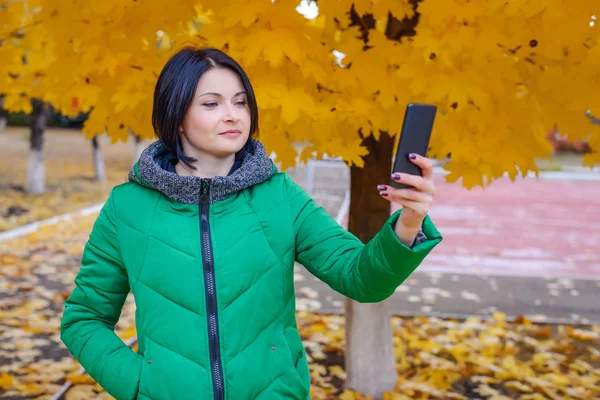 Donna sorridente che si fotografa al parco — Foto Stock