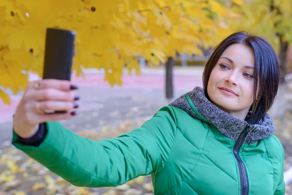 Donna sorridente che si fotografa al parco — Foto Stock