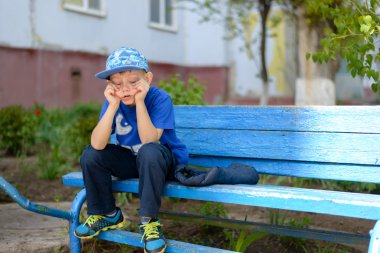 Bored little boy sitting waiting