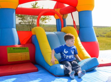 Genç çocuk bir bouncy kale üzerinde oynama