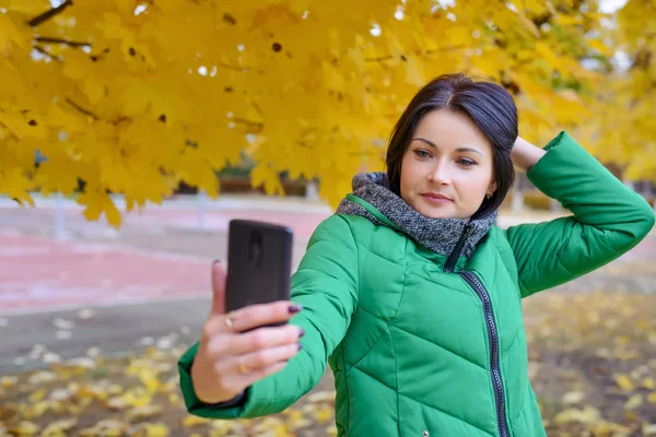 Hermosa dama tomando fotos de sí misma cerca del árbol —  Fotos de Stock