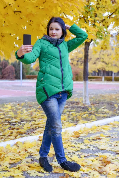 나무 근처에서 자신의 사진을 찍는 화려한 여자 — 스톡 사진