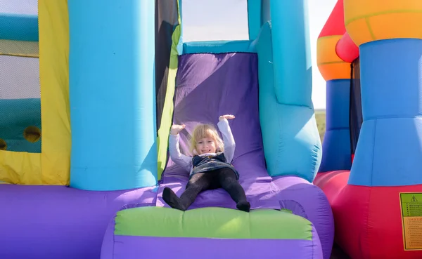 Cute little fair haired girl on a bouncy castle — Stock Photo, Image