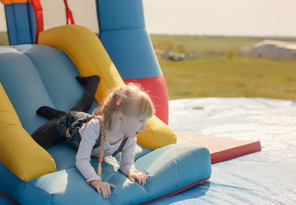 Excited little girl playing on a slide — Stock Photo, Image