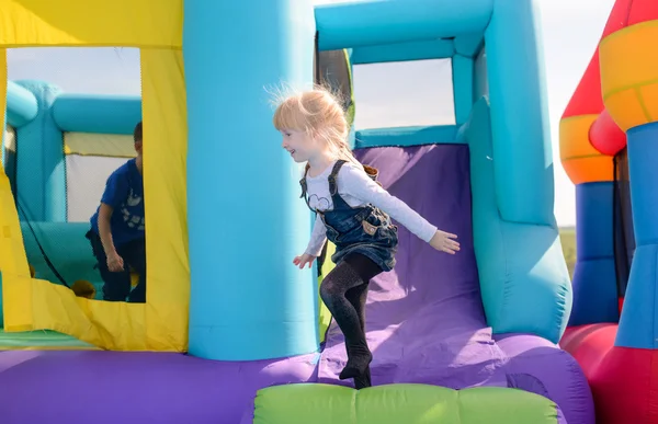 Pretty little blond girl playing on a slide Stock Photo