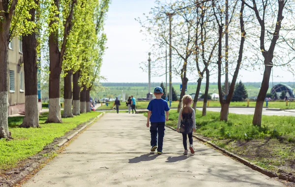 Kleine jongen en meisje lopen naar beneden een Avenue — Stockfoto