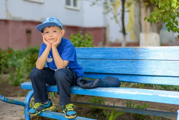 Happy confident young boy sitting waiting — Stock Photo, Image