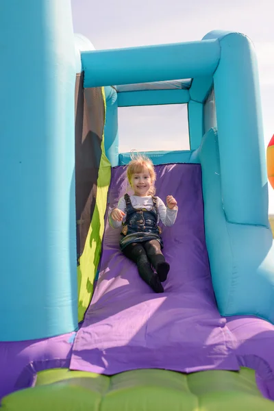 Excited little girl playing on a slide Royalty Free Stock Photos