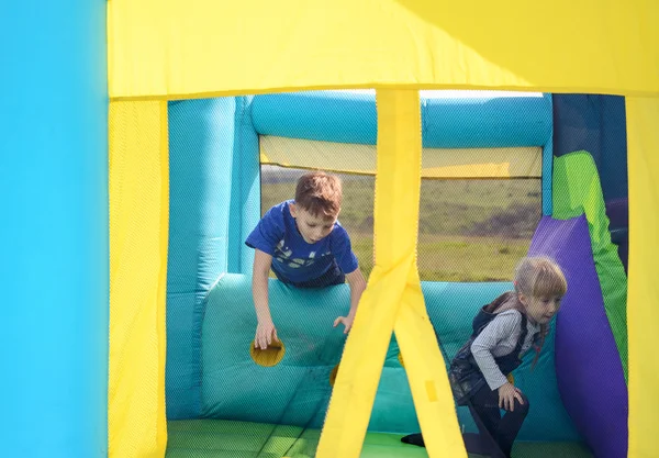 Little boy and girl playing on a bouncy castle Stock Photo