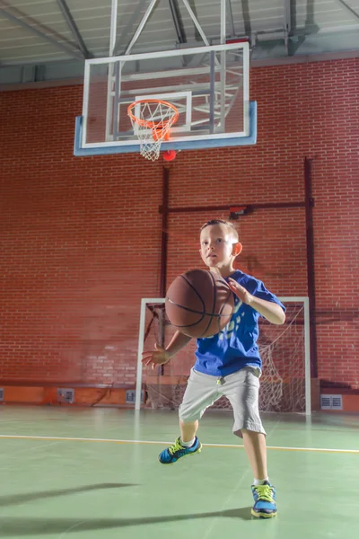 Menino desportivo jogando basquete — Fotografia de Stock