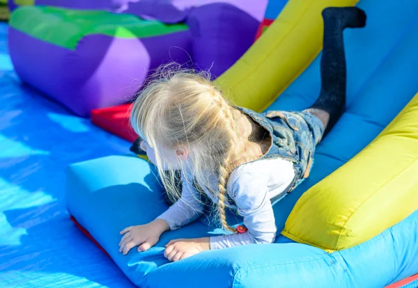 Happy girl on top of giant bouncy slide — Stock Photo, Image