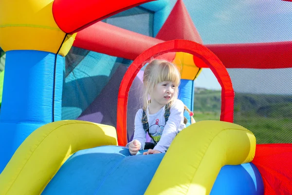 Menina feliz em cima de slide bouncy gigante — Fotografia de Stock