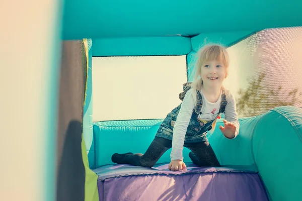 Chica feliz bajando diapositiva inflable —  Fotos de Stock