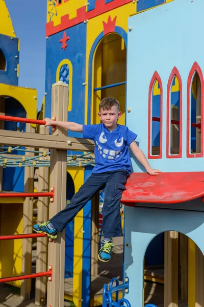 Child climbing down little house at playground