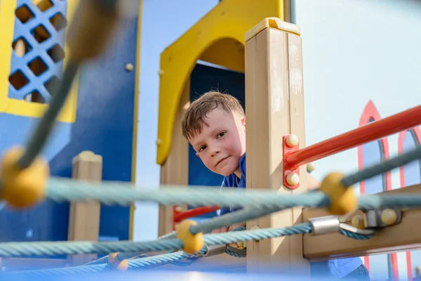 Carino bambino peering da playhouse — Foto Stock