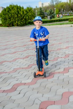 Bir oyuncak scooter üzerinde duran yakışıklı genç çocuk