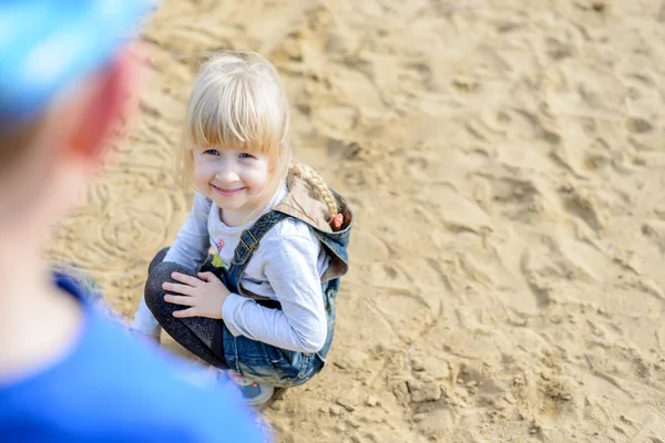 Вид сверху на ребенка, стоящего на коленях в песке — стоковое фото