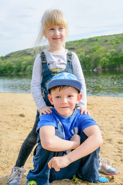 Glimlachend jongetje en meisje ontspannen op een strand — Stockfoto